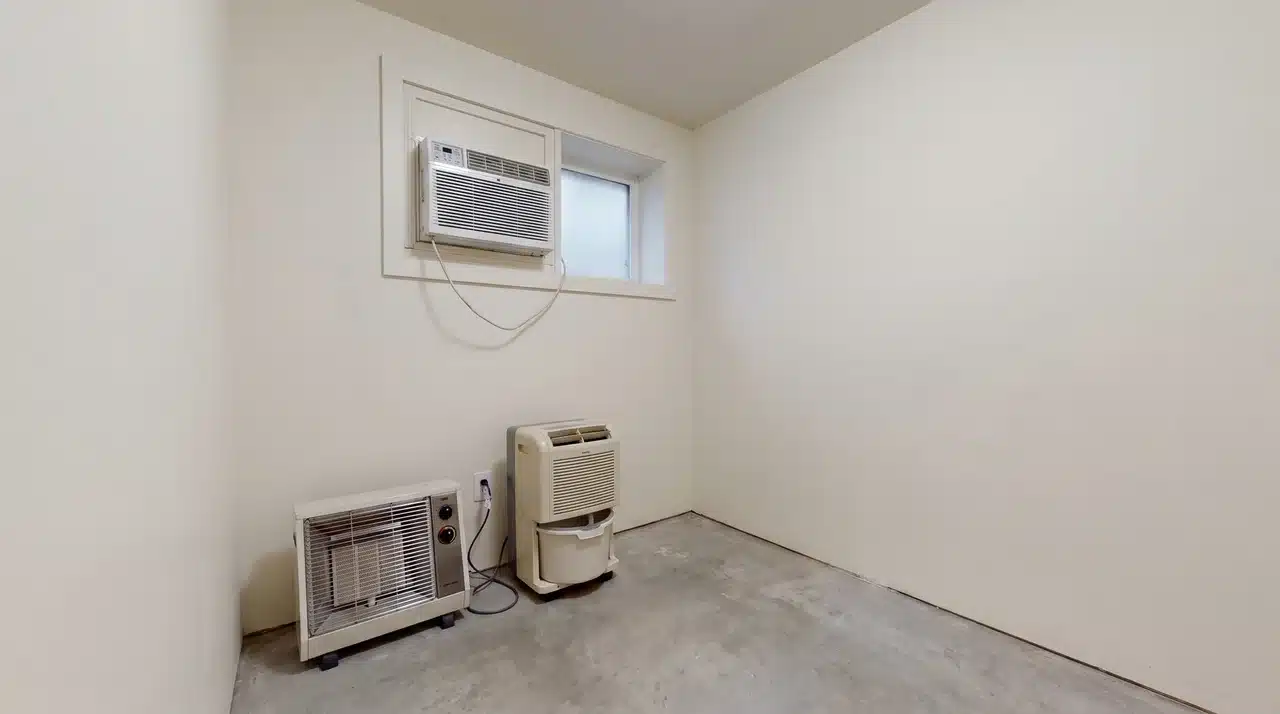 Window air conditioner, space heater, and dehumidifier positioned side by side in a utility room
