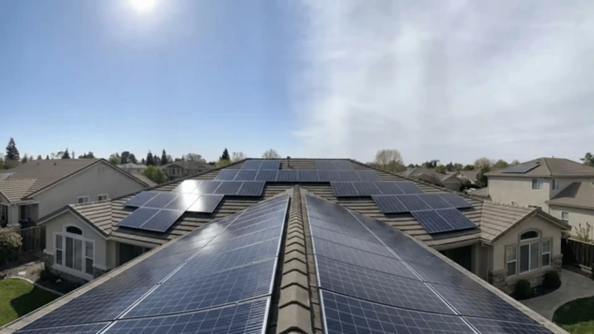 rooftop solar panels under mixed sun and cloud conditions showing uneven light across array