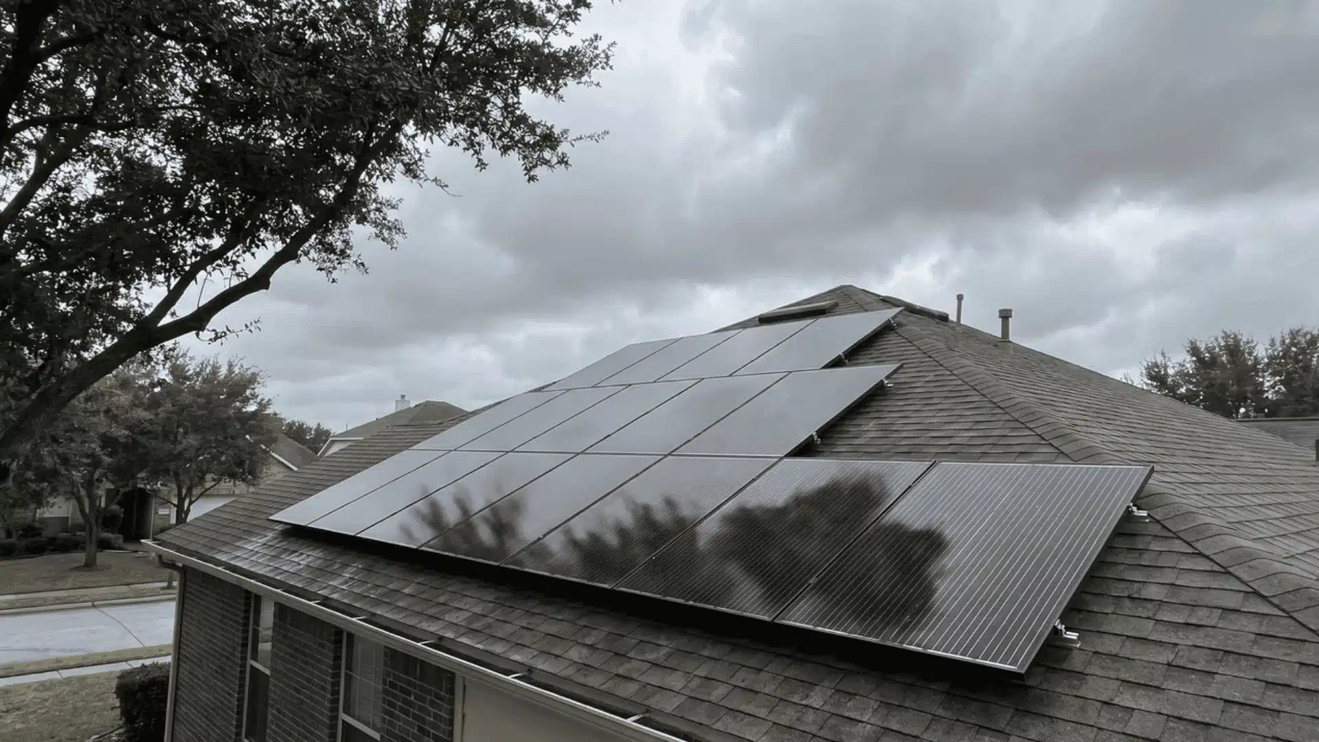 Rooftop solar panels installed on a suburban home with trees around it