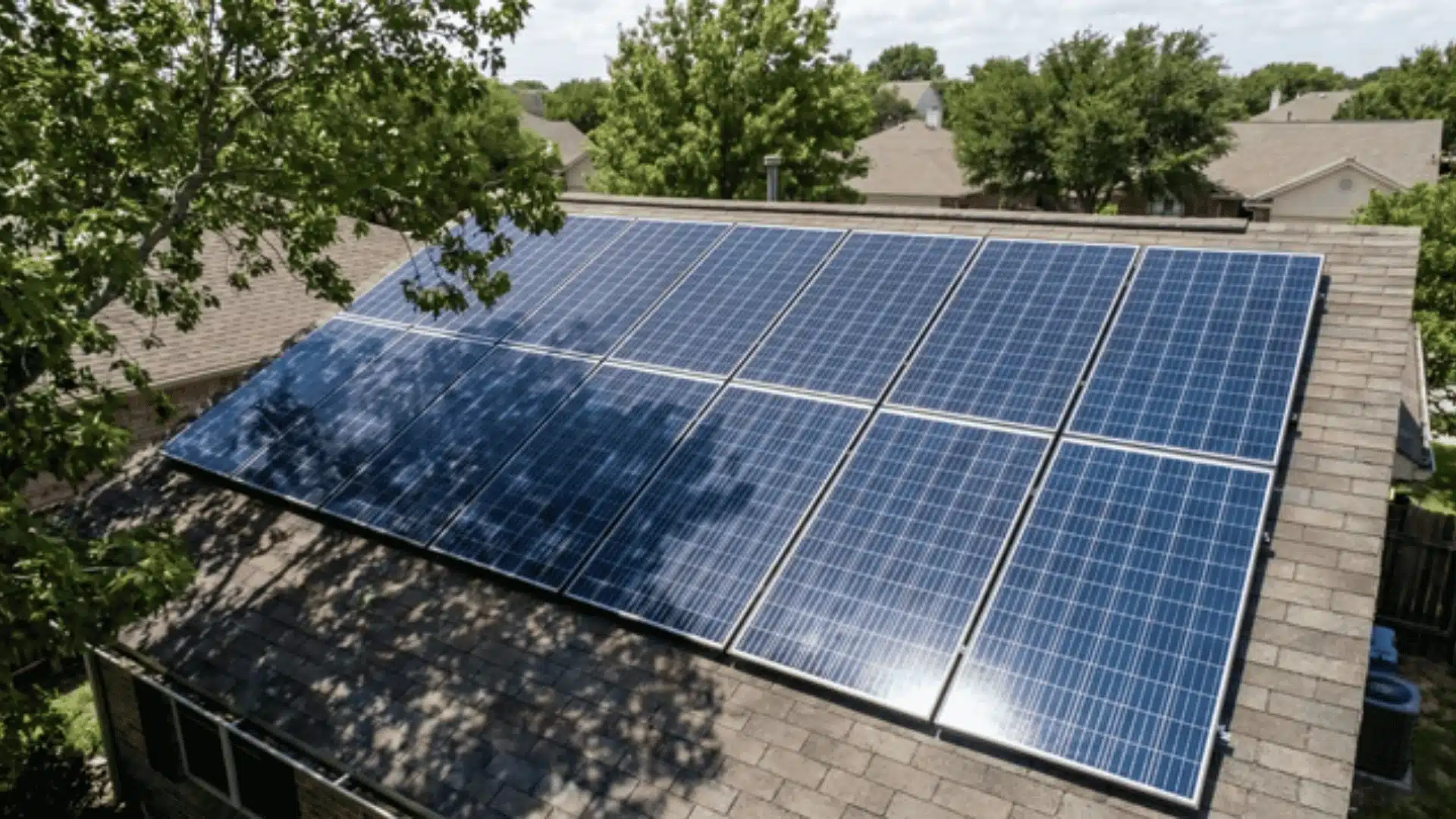 solar panel on rooftop partially shaded by tree shadows under angled sunlight