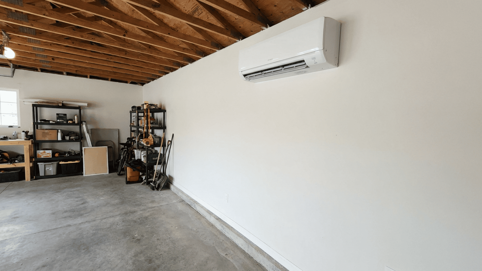 Wall-mounted indoor ductless unit installed on the wall of a converted garage with no ductwork