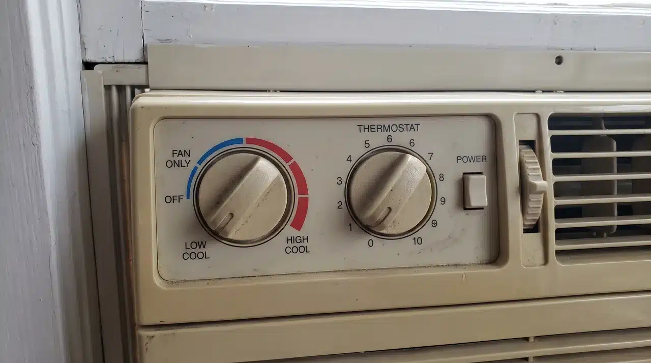 Control panel and thermostat dial on a window air conditioner