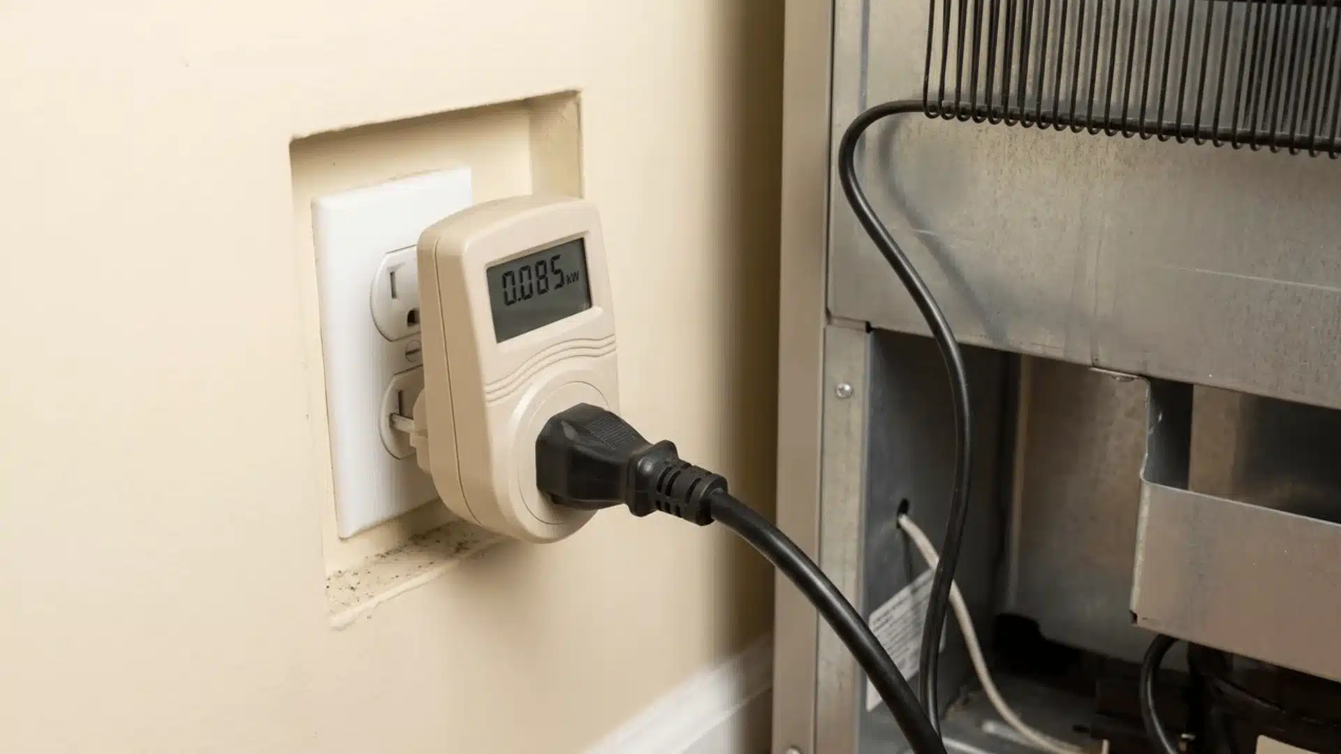 Plug-in power meter connected between a refrigerator's cord and a wall outlet