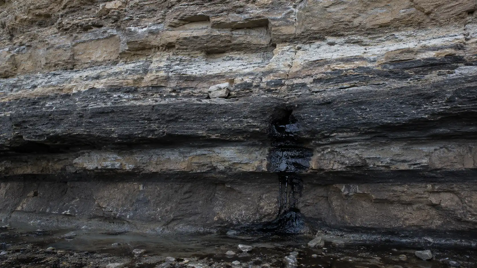 Underground rock layers showing crude oil trapped during the oil window stage of petroleum formation